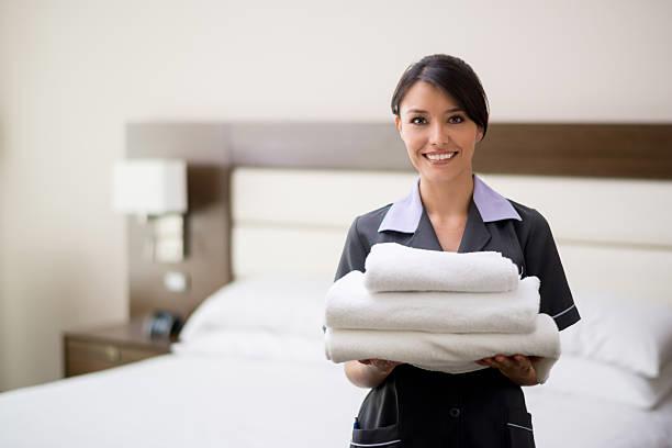 Maid With Fresh Clean Towels During Housekeeping In A Hotel Room